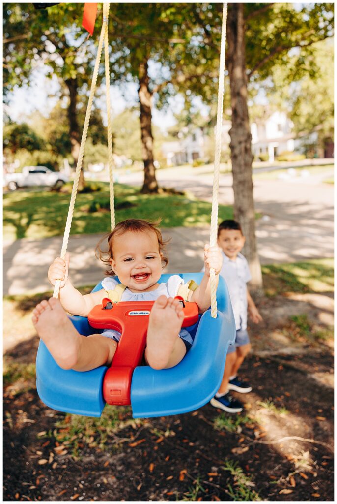 baby girl swinging in her Oak Forest Houston neighborhood